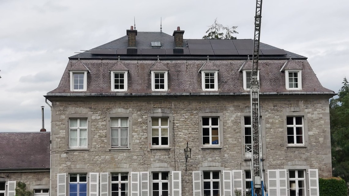 Installation de panneaux solaires sur un manoir historique.